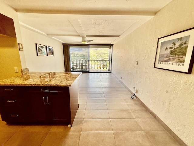 475 Front St Unit 308, Lahaina, HI 96761 - kitchen featuring a textured wall, light tile patterned floors, light stone counters, beam ceiling, and a peninsula