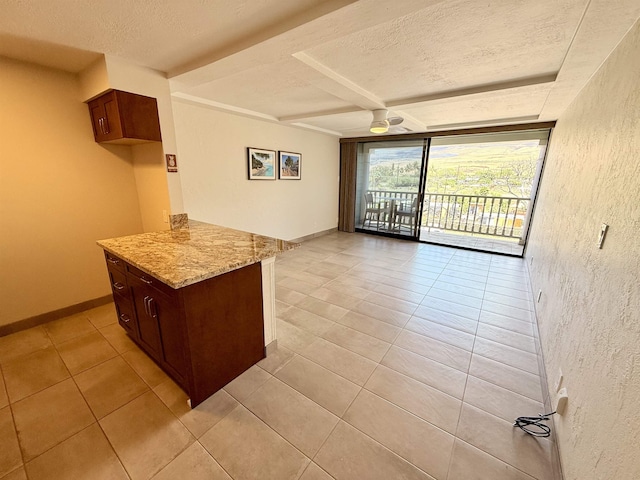 475 Front St Unit 308, Lahaina, HI 96761 - kitchen with light stone counters, light tile patterned flooring, a ceiling fan, a textured ceiling, and beam ceiling