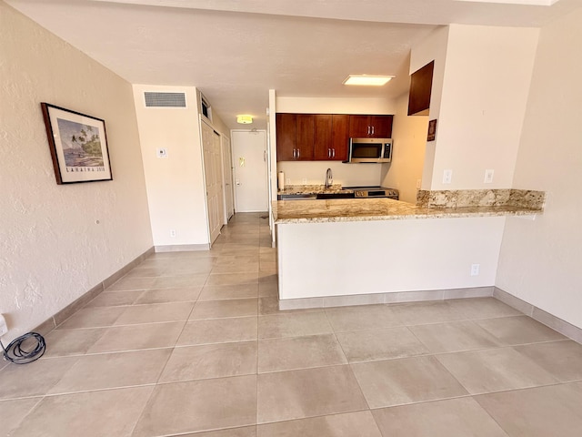 475 Front St Unit 308, Lahaina, HI 96761 - kitchen featuring stainless steel appliances, a sink, a peninsula, light stone countertops, and light tile patterned floors