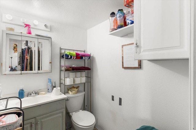 bathroom with vanity, a textured ceiling, and toilet