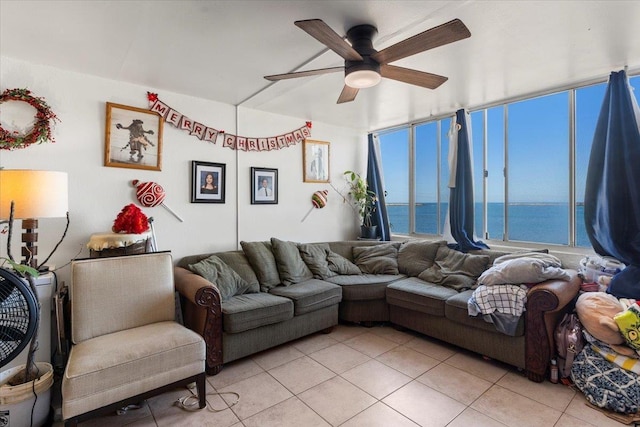 tiled living room with a water view and ceiling fan