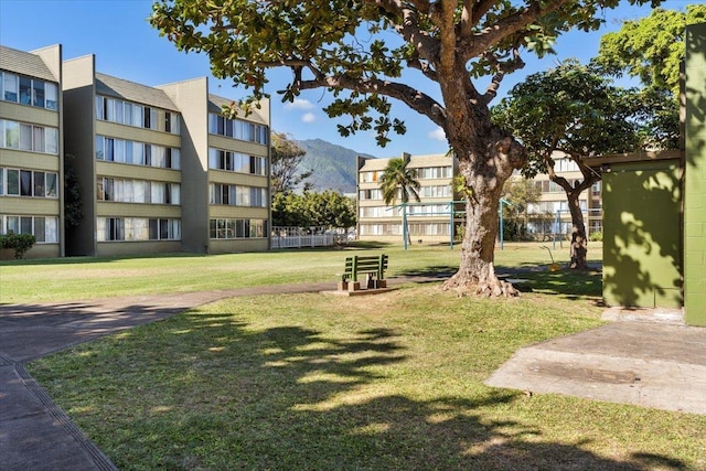 surrounding community with a mountain view and a lawn