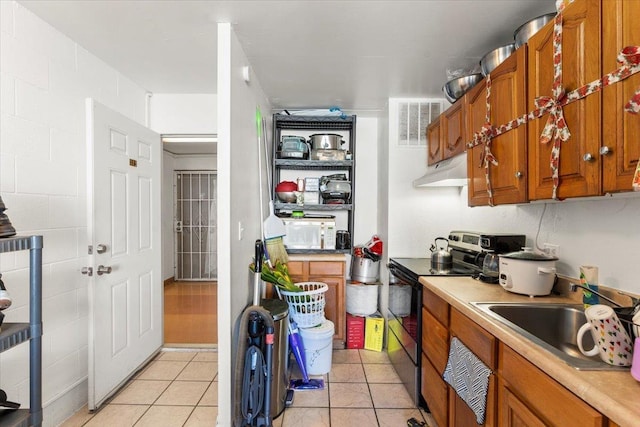 kitchen with light tile patterned floors, black / electric stove, and sink