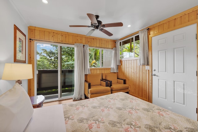 bedroom featuring ceiling fan, access to outside, and wooden walls