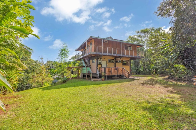 back of property with a wooden deck, a yard, and a sunroom