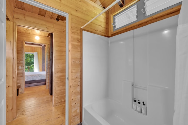 bathroom with hardwood / wood-style flooring and wooden walls