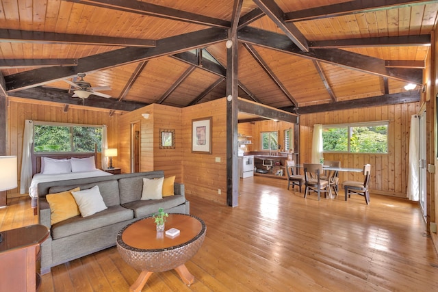 living room featuring wood ceiling, ceiling fan, light wood-type flooring, and wood walls