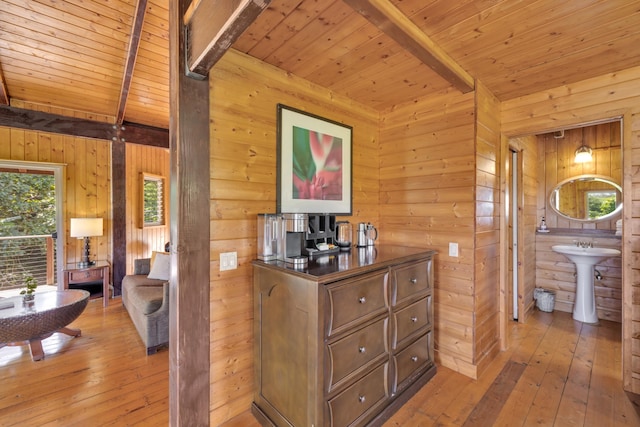 corridor featuring wooden walls, wood ceiling, and light hardwood / wood-style flooring