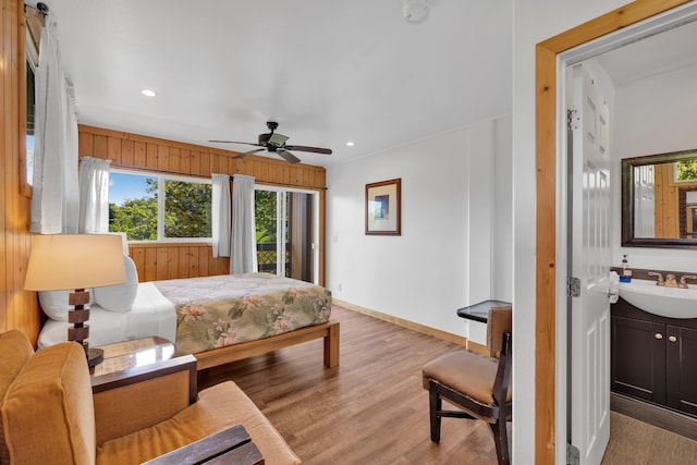 bedroom featuring ceiling fan, access to exterior, light hardwood / wood-style floors, and sink