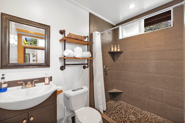 bathroom featuring walk in shower, vanity, and toilet