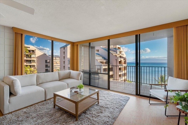 4327 Lower Honoapiilani Rd Unit 801, Lahaina, HI 96761 - living area featuring wood finished floors, a water view, healthy amount of natural light, and a textured ceiling