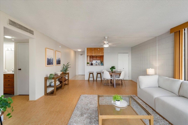 4327 Lower Honoapiilani Rd Unit 801, Lahaina, HI 96761 - living room featuring ceiling fan, light wood-type flooring, and a textured ceiling