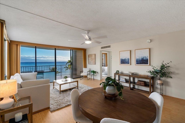 4327 Lower Honoapiilani Rd Unit 801, Lahaina, HI 96761 - living room featuring a water view, ceiling fan, a textured ceiling, and light wood finished floors