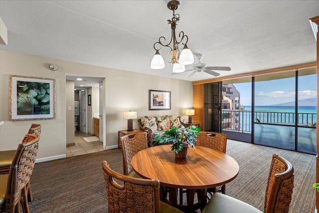 4327 Lower Honoapiilani Rd Unit 802, Lahaina, HI 96761 - dining area with light carpet, baseboards, a water view, expansive windows, and a chandelier