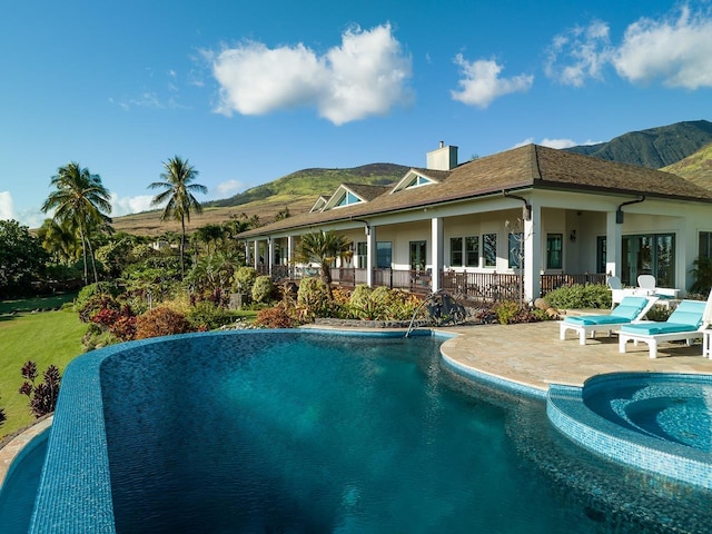 rear view of house with a mountain view and a patio area