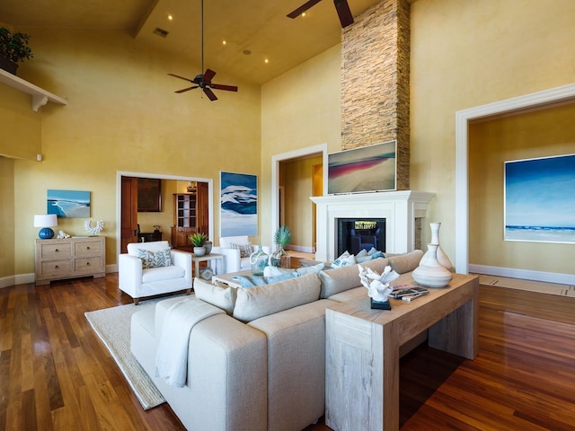 living room with dark hardwood / wood-style flooring, ceiling fan, a fireplace, and high vaulted ceiling