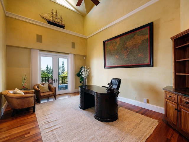 home office with dark hardwood / wood-style flooring, ceiling fan, french doors, and high vaulted ceiling