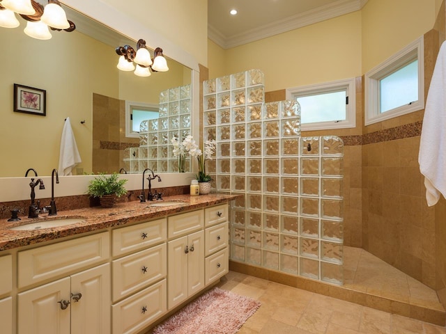 bathroom with a tile shower, vanity, and ornamental molding