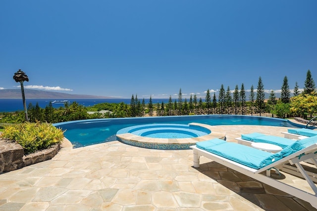 view of pool with a patio area and an in ground hot tub