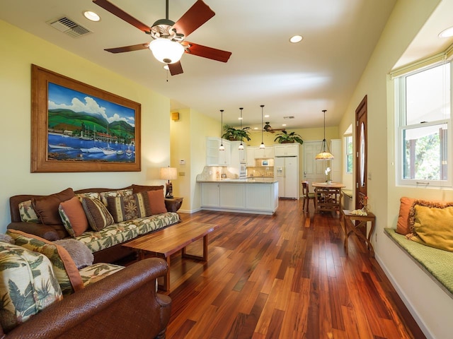 living room featuring ceiling fan and dark hardwood / wood-style flooring