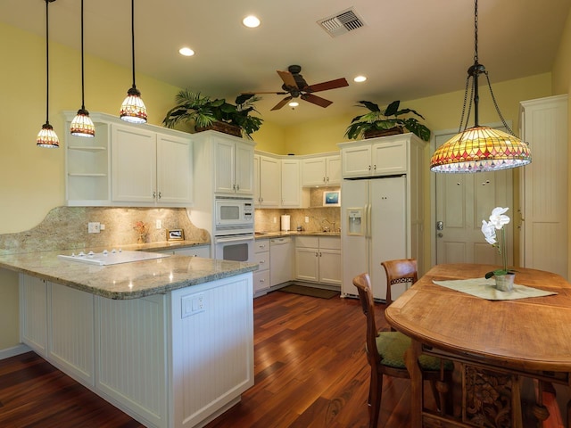 kitchen featuring kitchen peninsula, dark hardwood / wood-style flooring, white appliances, white cabinetry, and hanging light fixtures