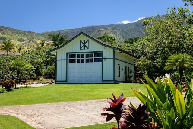 garage featuring a mountain view and a yard