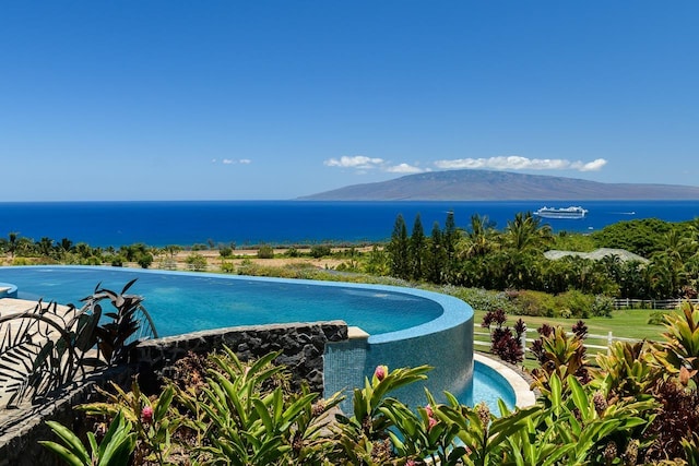 view of swimming pool with a water and mountain view