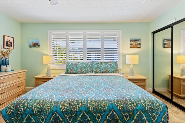 tiled bedroom featuring a textured ceiling, ceiling fan, and a closet