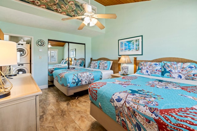 bedroom with ceiling fan, a closet, and stacked washer / dryer