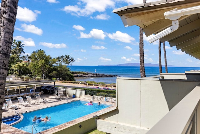 view of pool featuring a water view and a patio area