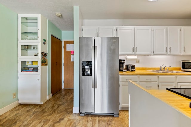 kitchen featuring stainless steel appliances, white cabinetry, and sink