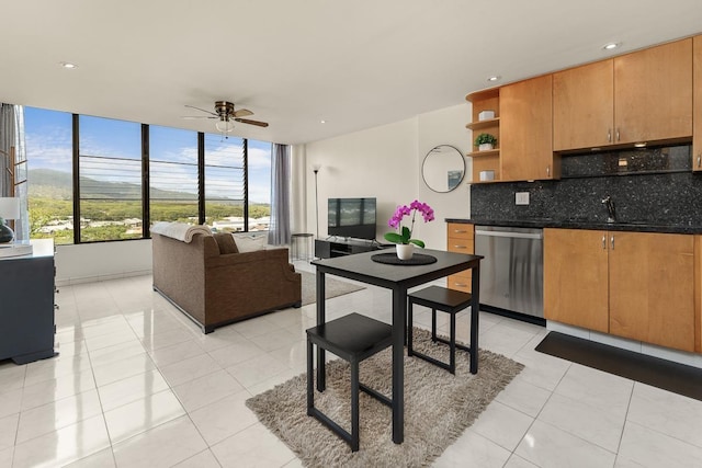 kitchen with light tile patterned flooring, sink, dishwasher, ceiling fan, and backsplash