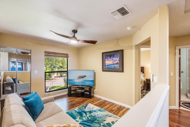 living room featuring hardwood / wood-style floors and ceiling fan