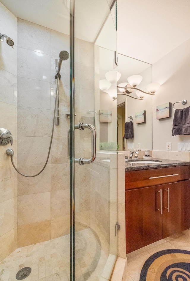 bathroom with vanity, a shower with shower door, and an inviting chandelier