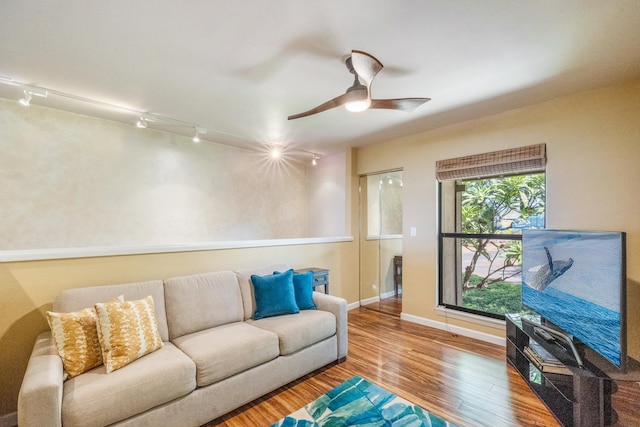 living room featuring hardwood / wood-style floors, rail lighting, and ceiling fan