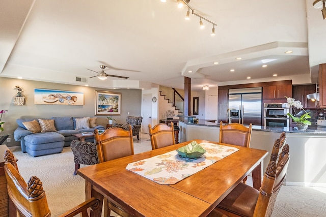 carpeted dining area with ceiling fan