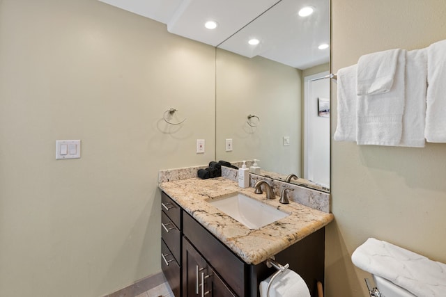 bathroom featuring toilet, recessed lighting, and vanity