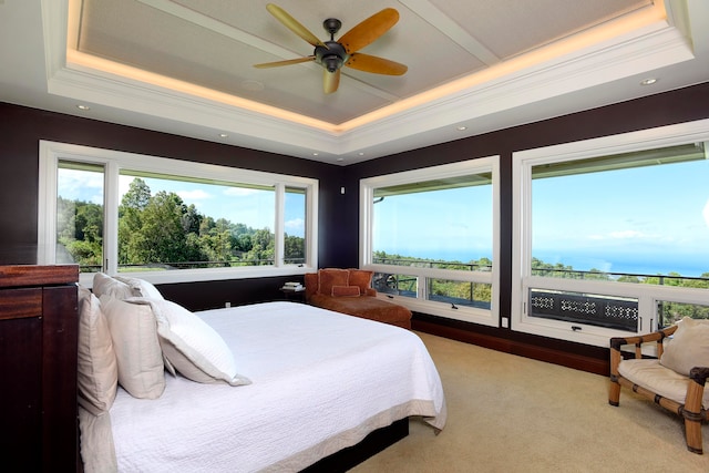 bedroom with light carpet, a tray ceiling, ornamental molding, and ceiling fan