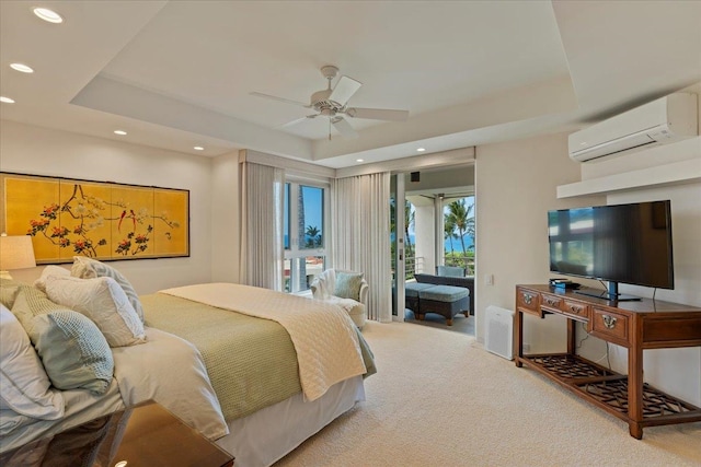 carpeted bedroom with ceiling fan, a wall mounted air conditioner, a tray ceiling, and access to outside