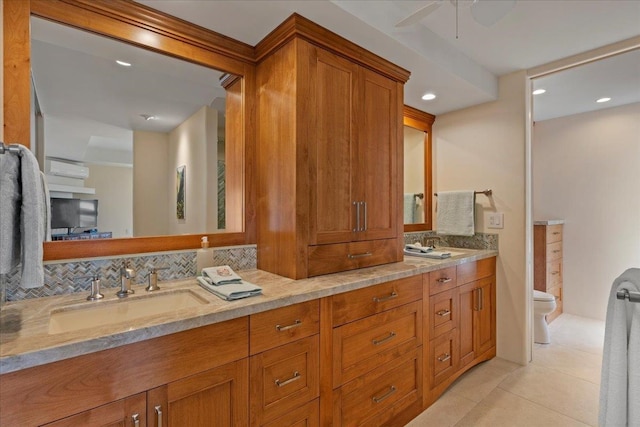 bathroom featuring ceiling fan, vanity, tile patterned floors, toilet, and backsplash