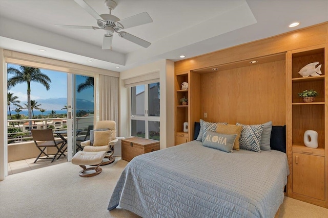 carpeted bedroom with a raised ceiling, access to outside, and ceiling fan