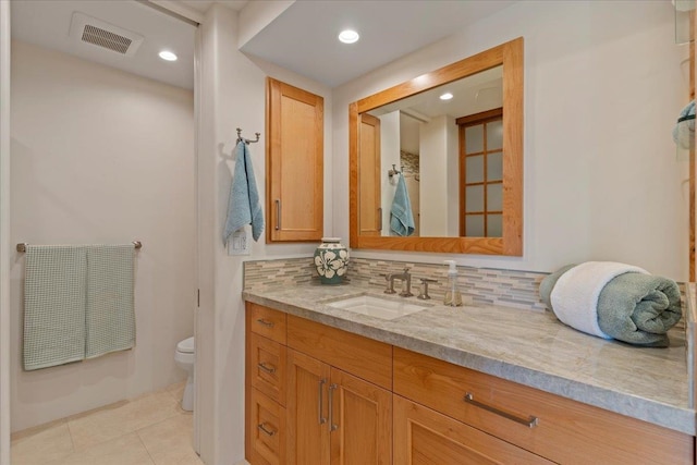 bathroom with decorative backsplash, tile patterned flooring, vanity, and toilet