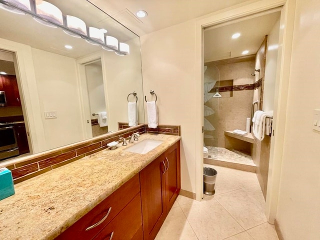 bathroom featuring walk in shower, tile patterned flooring, vanity, and tasteful backsplash