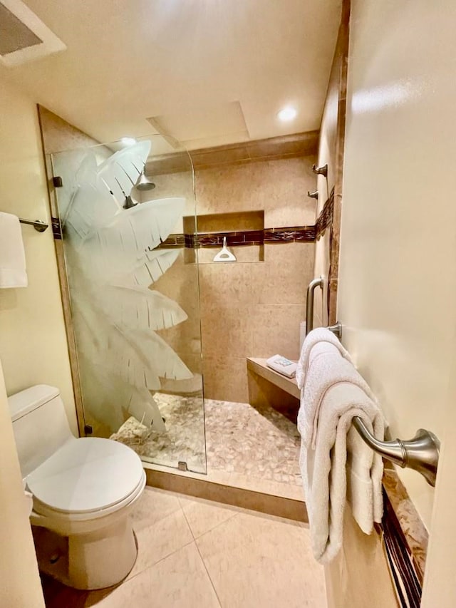 bathroom with tile patterned flooring, a shower with door, and toilet