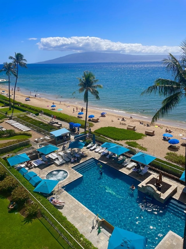 birds eye view of property with a water view and a beach view