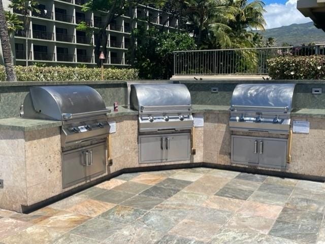 view of patio featuring grilling area, a mountain view, and exterior kitchen