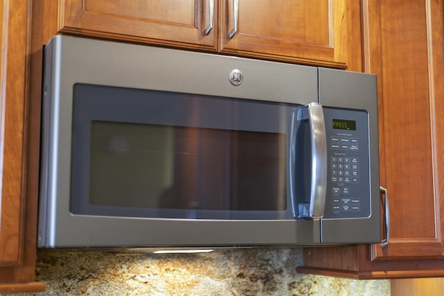 3445 Lower Honoapiilani Rd Unit 309, Lahaina, HI 96761 - kitchen view of stainless steel microwave, brown cabinets, and stone countertops