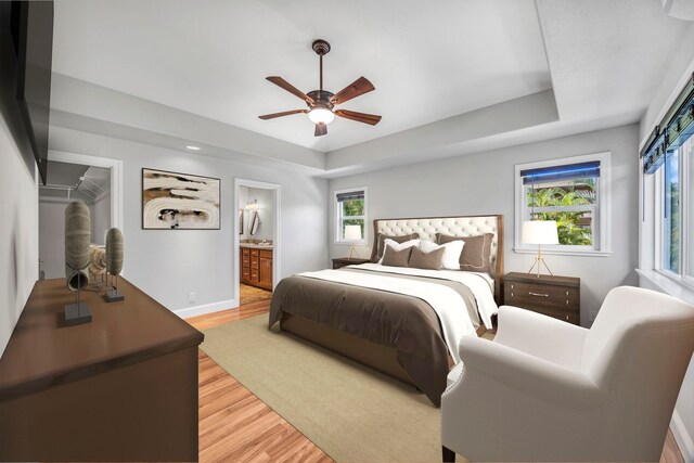 207 Kahana Ridge Dr Unit 132, Lahaina, HI 96761 - bedroom featuring a tray ceiling, light wood-style flooring, baseboards, connected bathroom, and ceiling fan