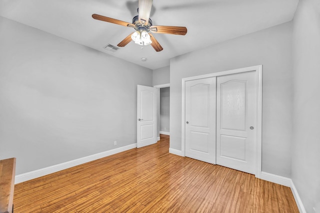 207 Kahana Ridge Dr Unit 132, Lahaina, HI 96761 - unfurnished bedroom featuring light wood finished floors, a closet, baseboards, and a ceiling fan