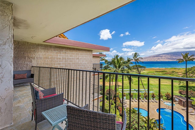 balcony featuring a water and mountain view